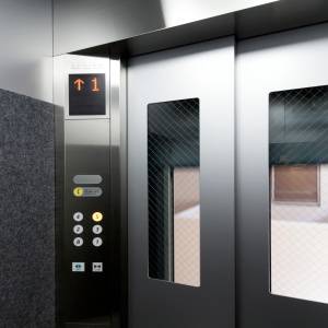 操作盤と小窓のついた、エレベーター内部の扉。 
