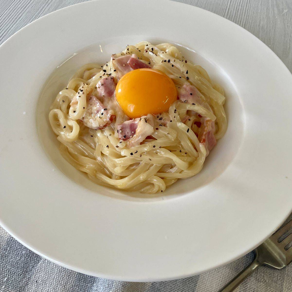 テーブルマーク公式の「レンジで作る！カルボ和えうどん」のレシピ