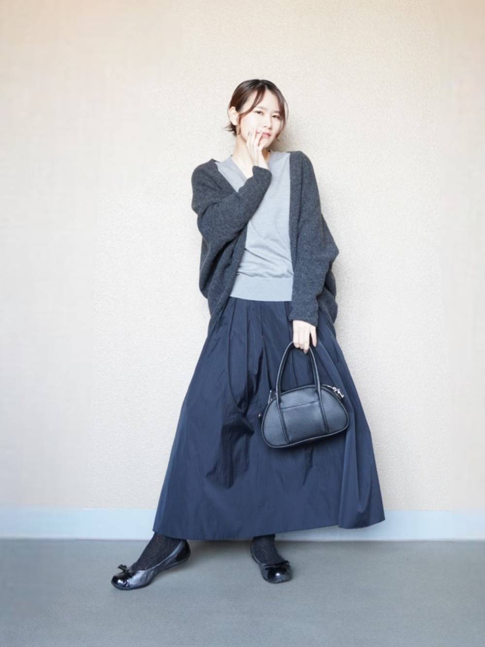 ユニクロのボレロにブラックスカートを合わせた女性