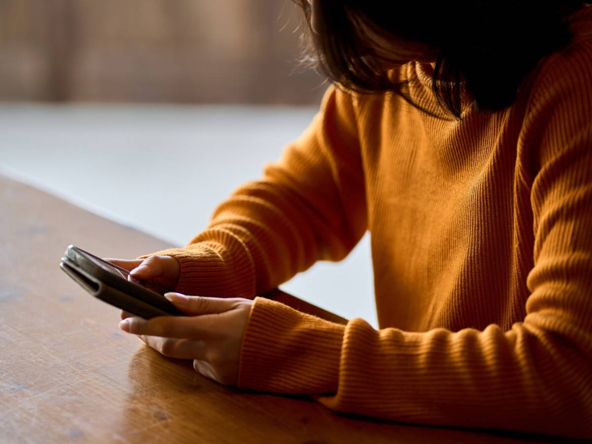 スマホを見て落ち込む女性