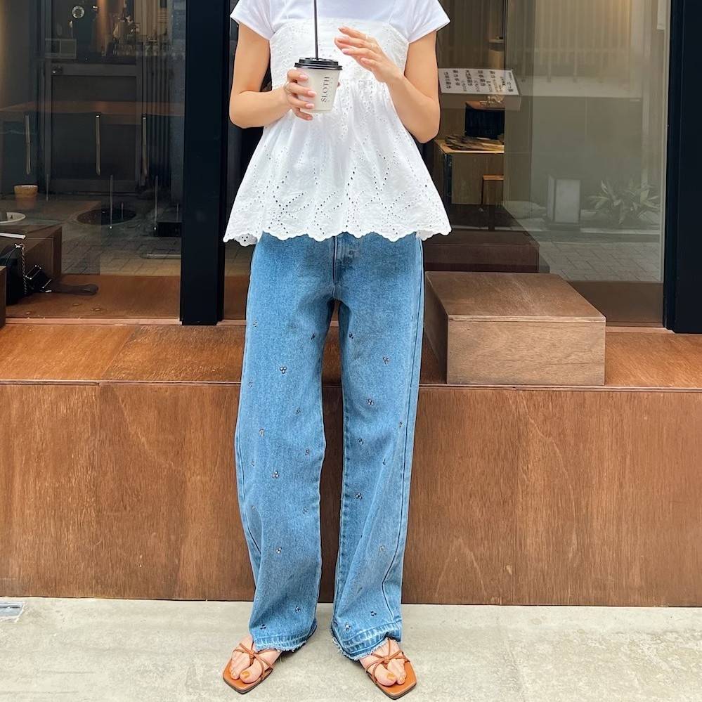 白トップスにデニムパンツを合わせた女性