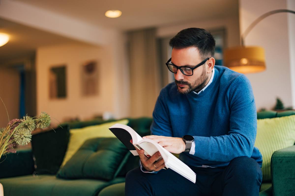 ソファに座って読書する男性