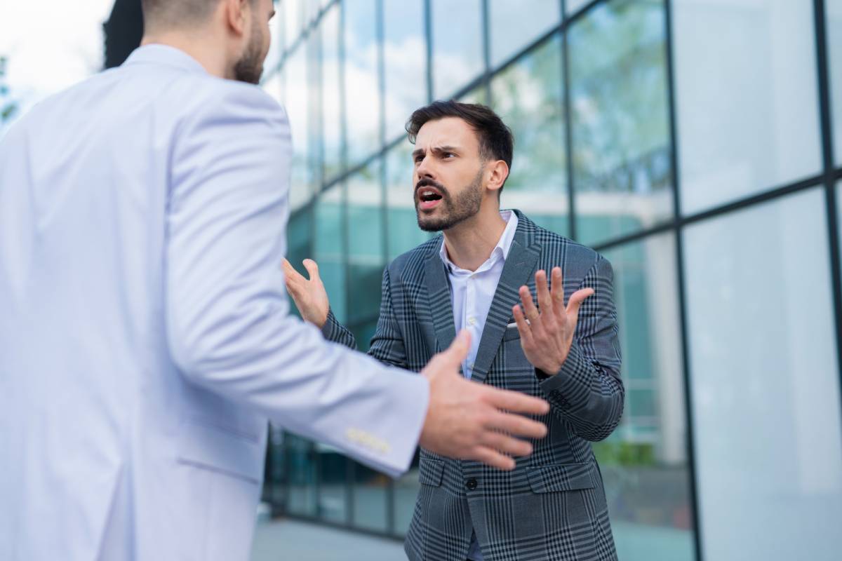 外で言い合いをする2人の男性