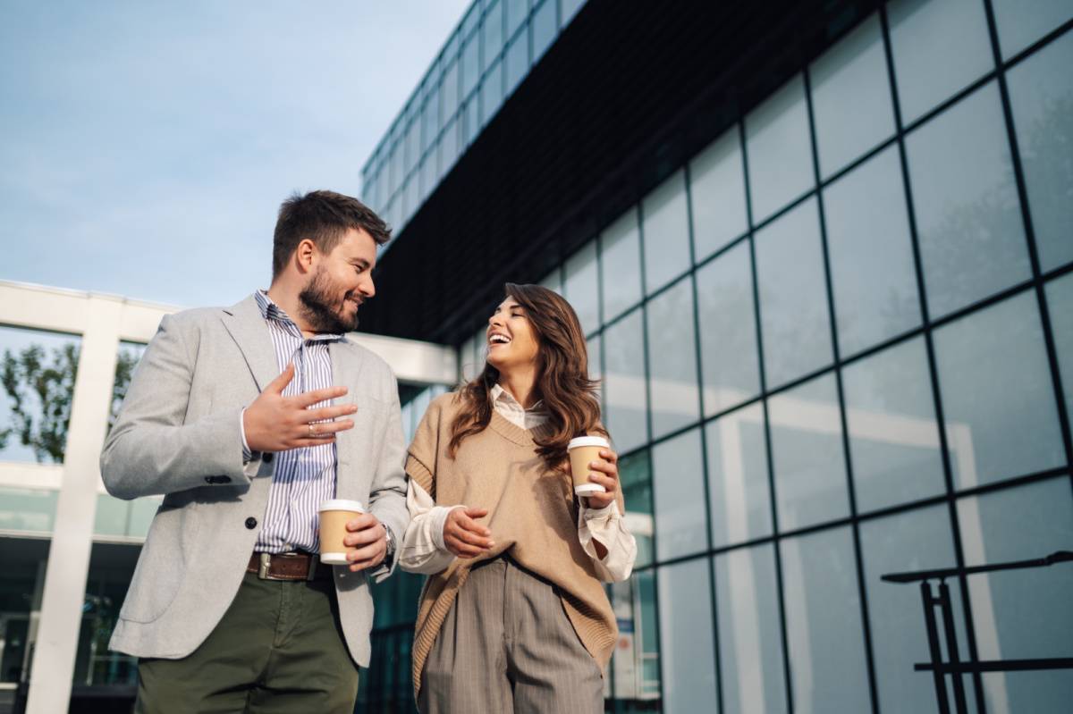 コーヒー片手に外を歩きながら話す男女
