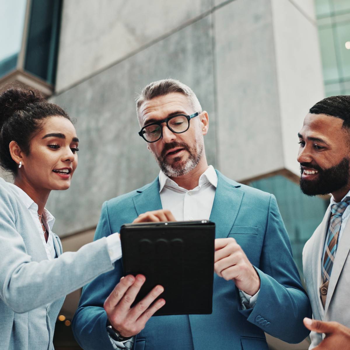 外でタブレットを見ながら話し合う男女