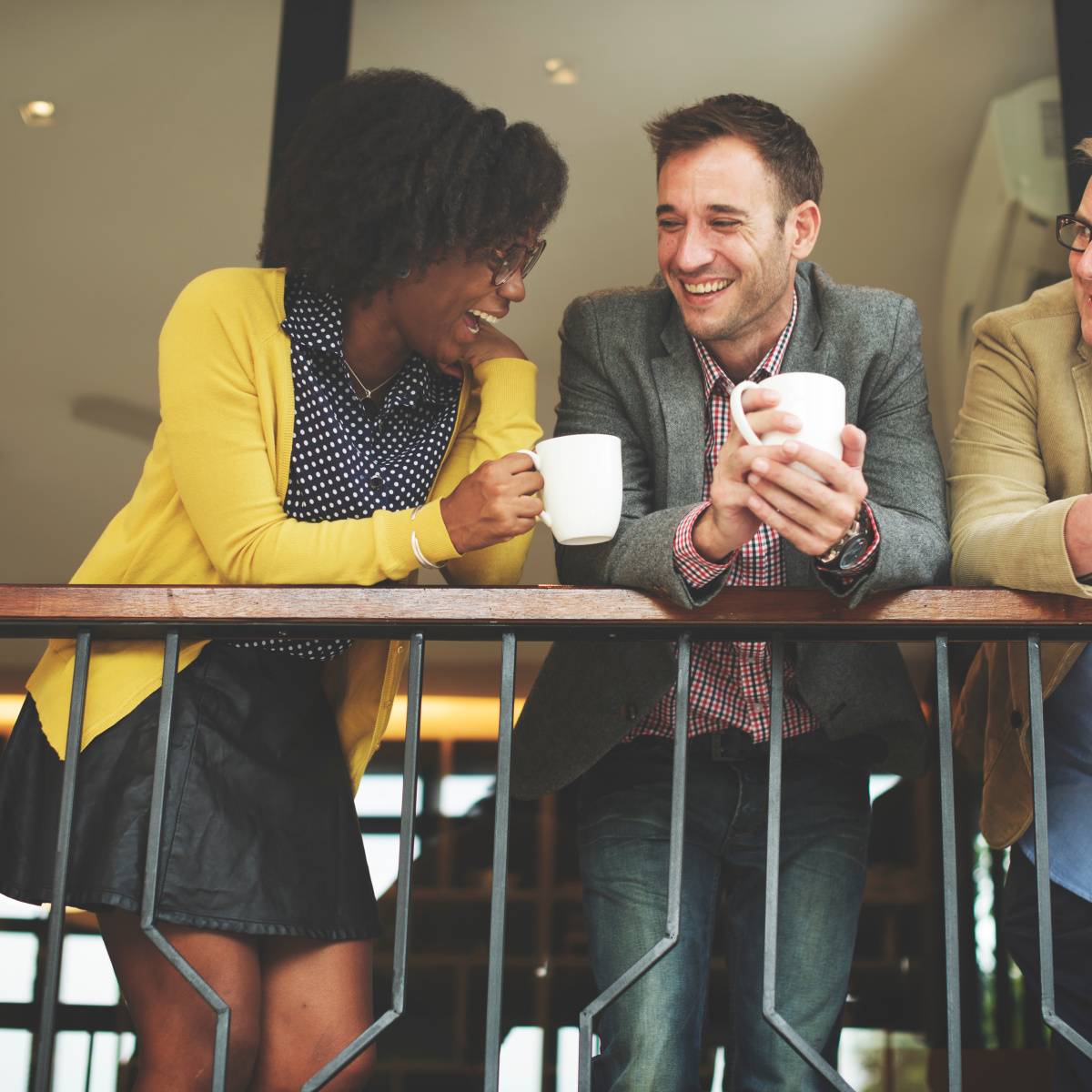 コーヒーを飲みながらバルコニーで話す男女