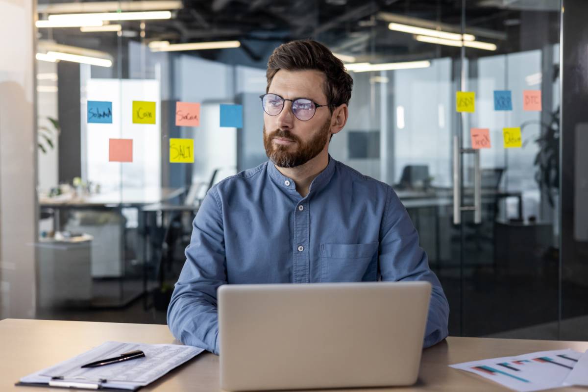 パソコンで仕事中に横に目をやる男性