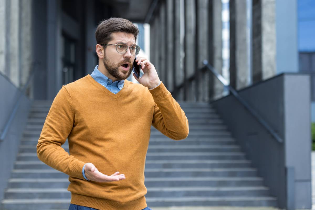 外で電話しながら怒る男性