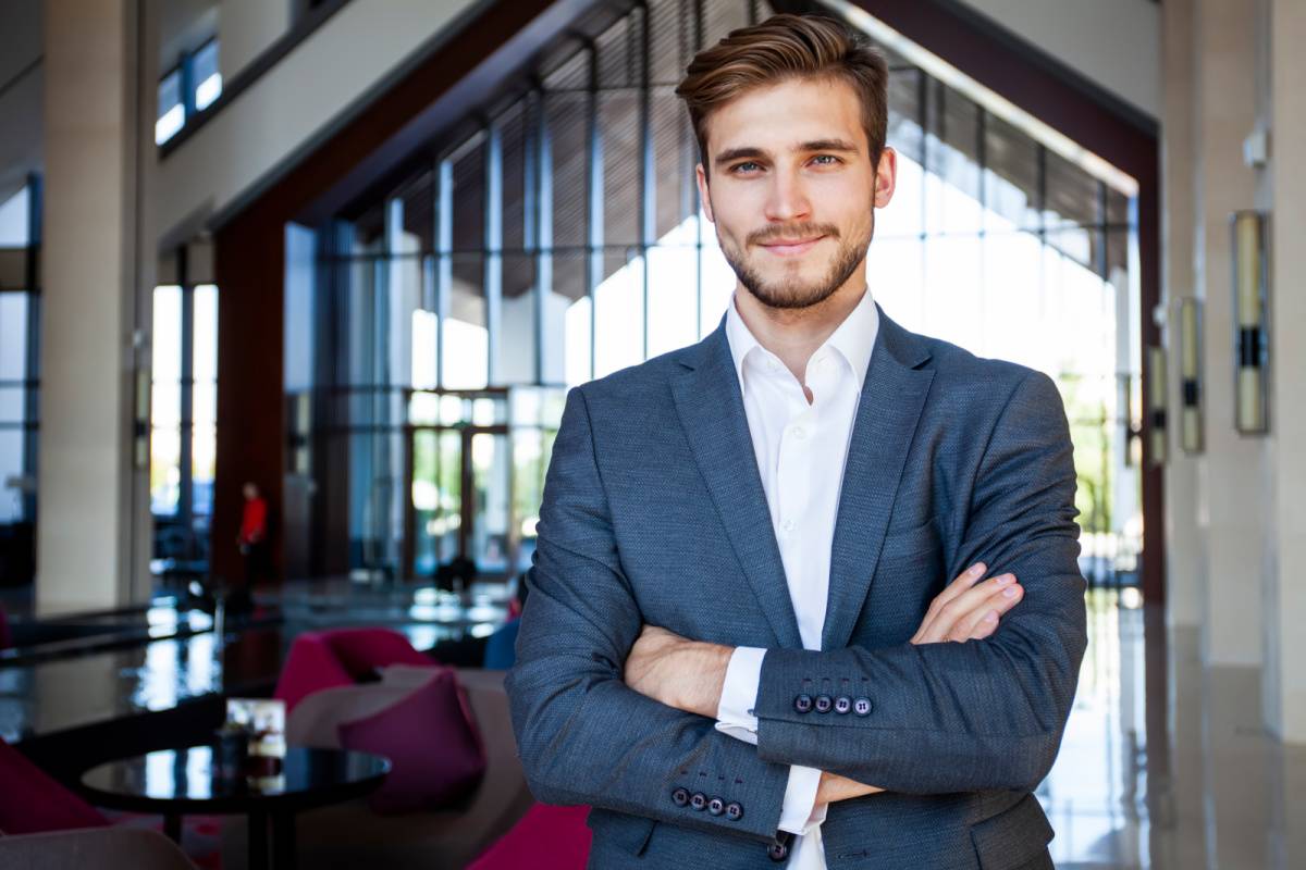 腕を組んで笑顔を向ける男性