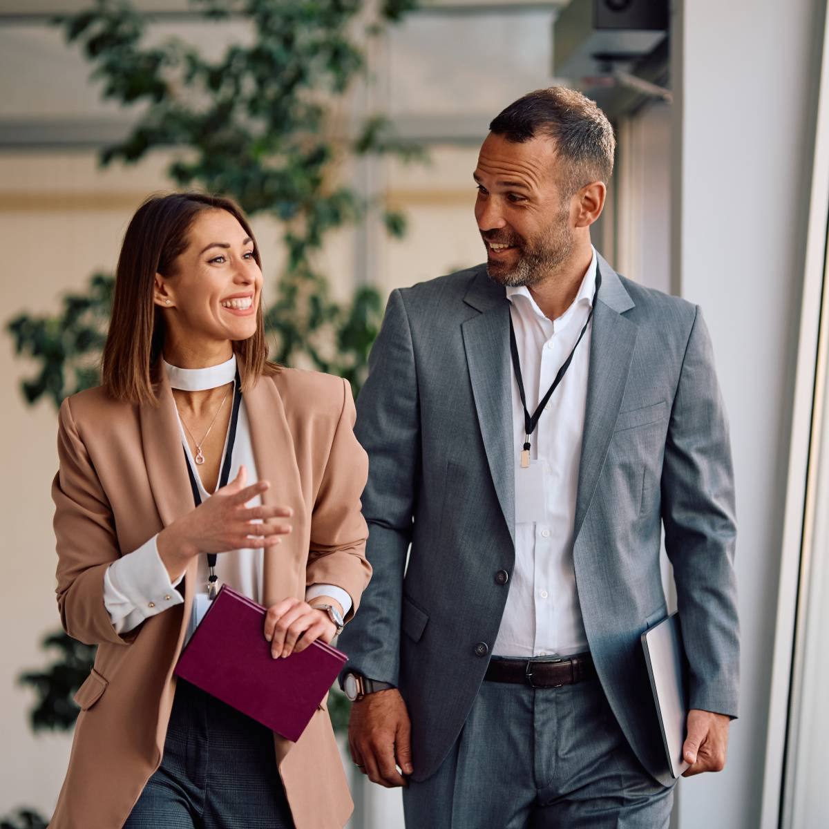 オフィスを歩きながら話す笑顔の男女