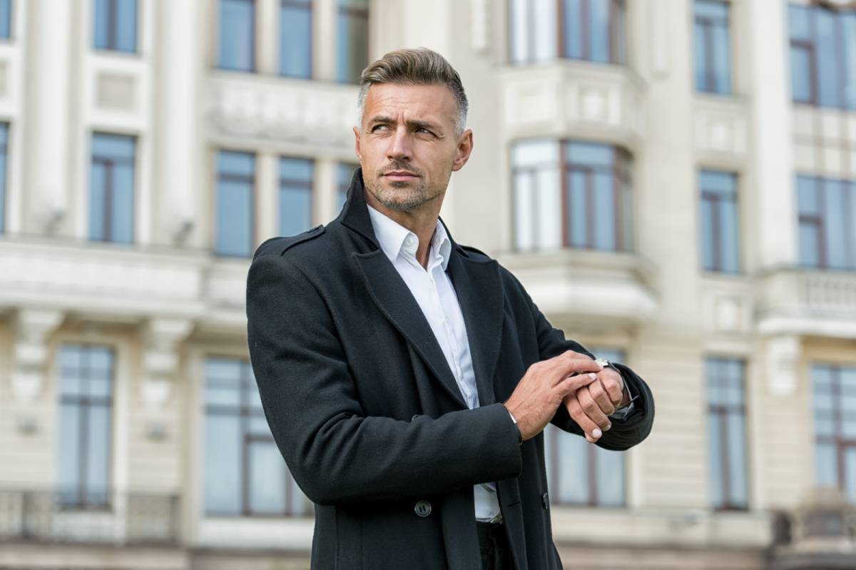 外で時計を確認する男性