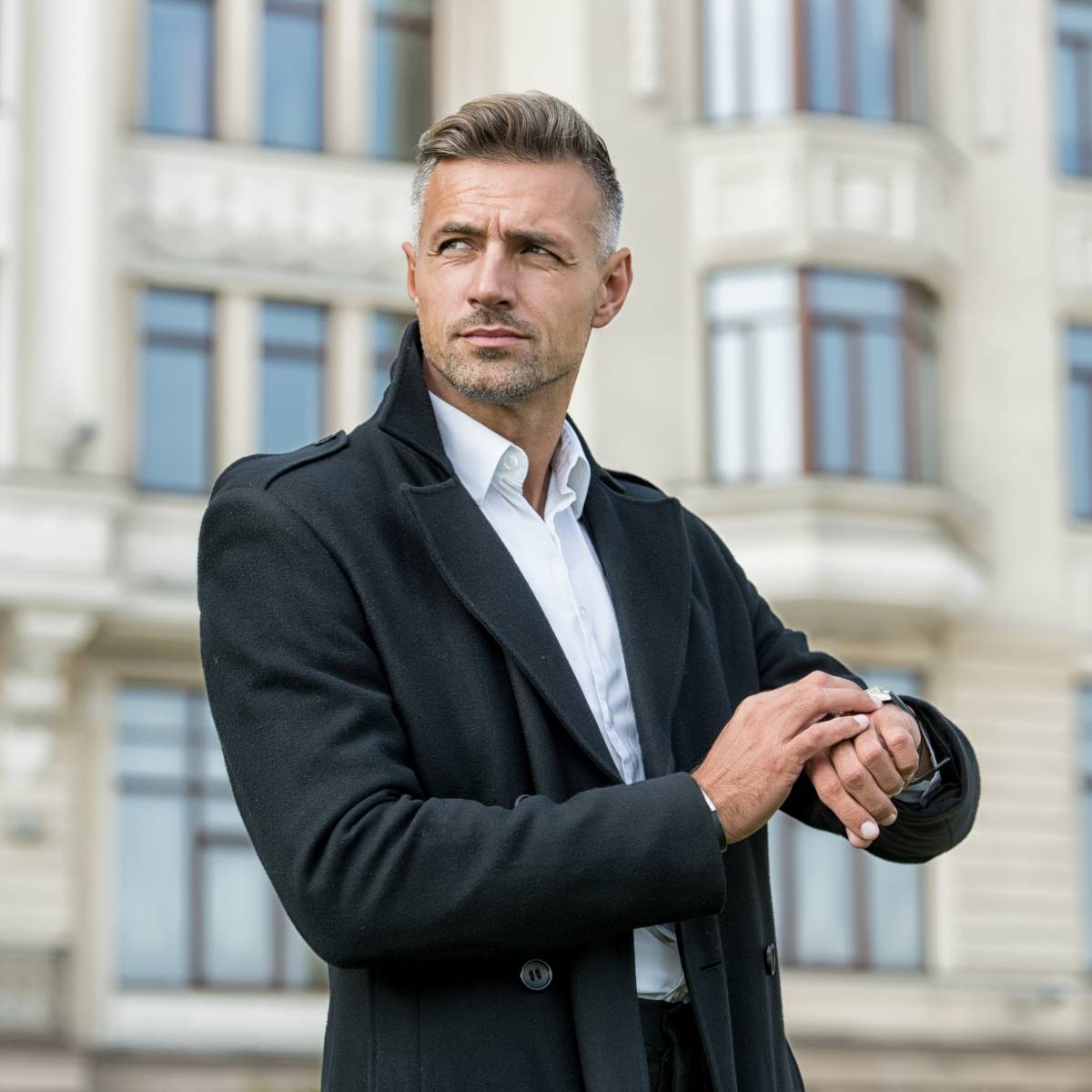 外で時計を確認する男性