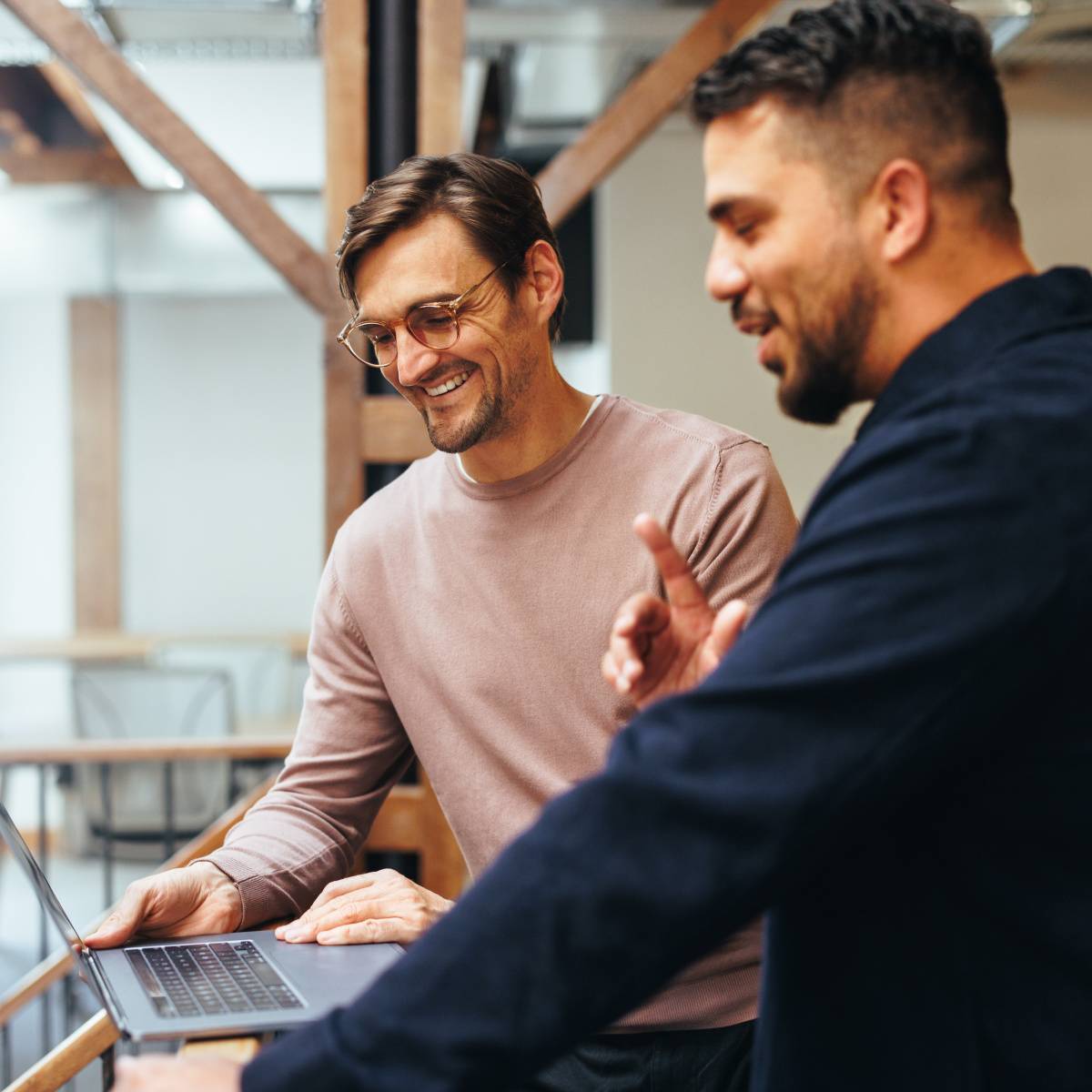 パソコンを開きながら話し合う2人の男性