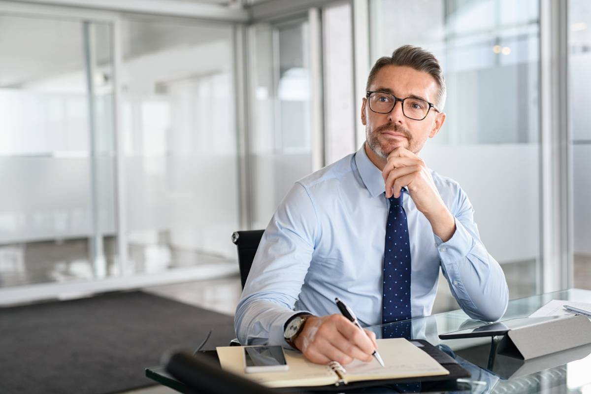 メモを取りながら考える男性