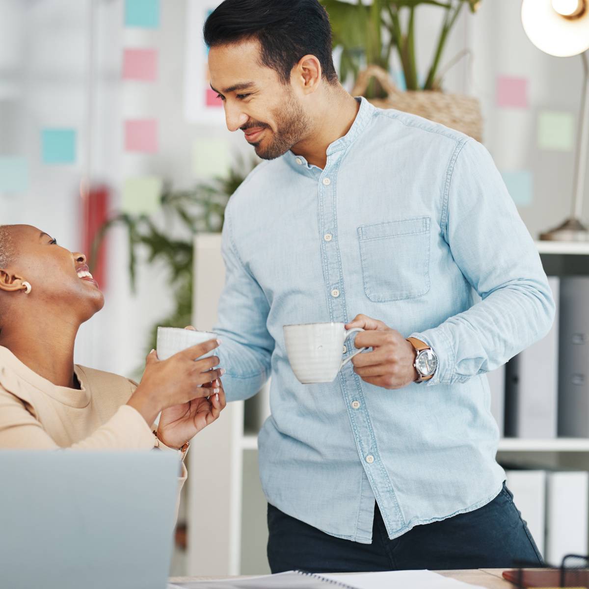 同僚にマグカップを手渡す男性