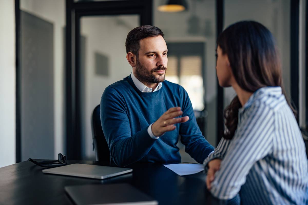 会議室で同僚と話す男性