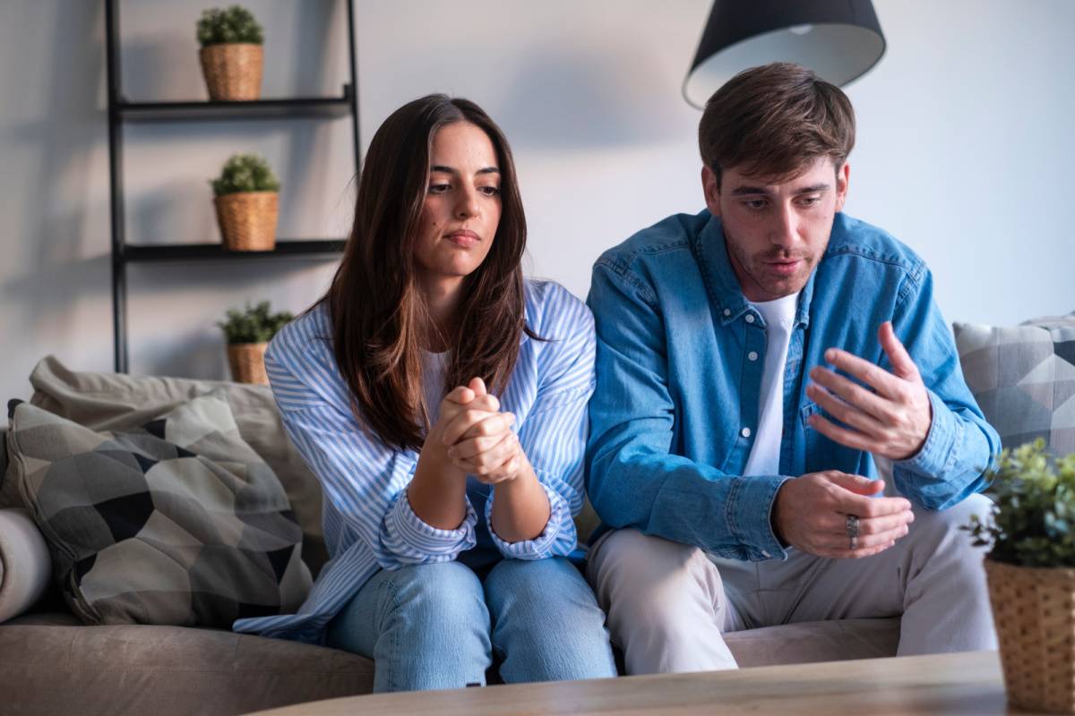 ソファに座って話し合うカップル