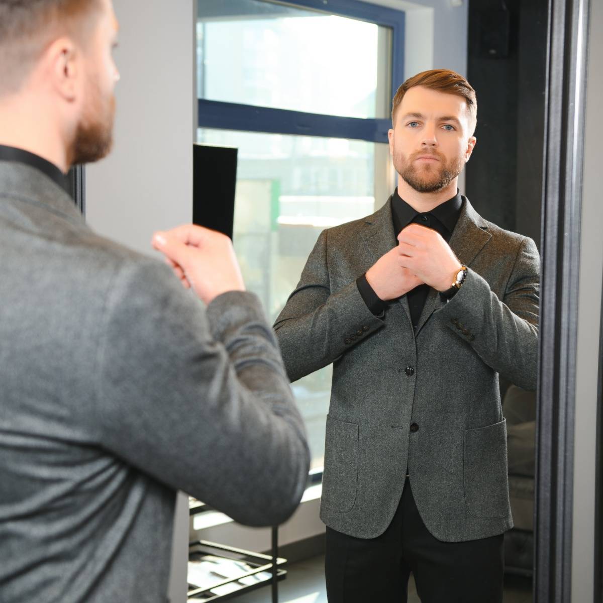 鏡の前で身だしなみを整える男性