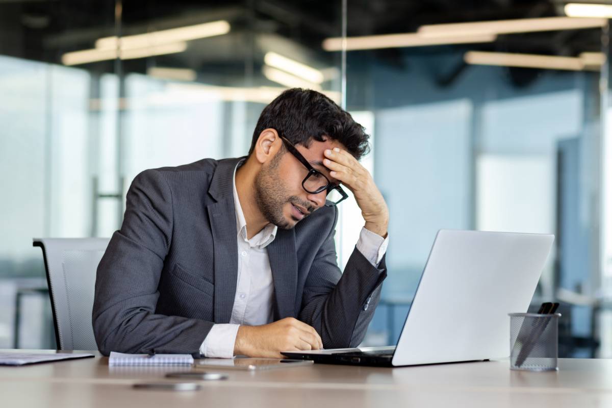 パソコンの前で落ち込んだ様子の男性