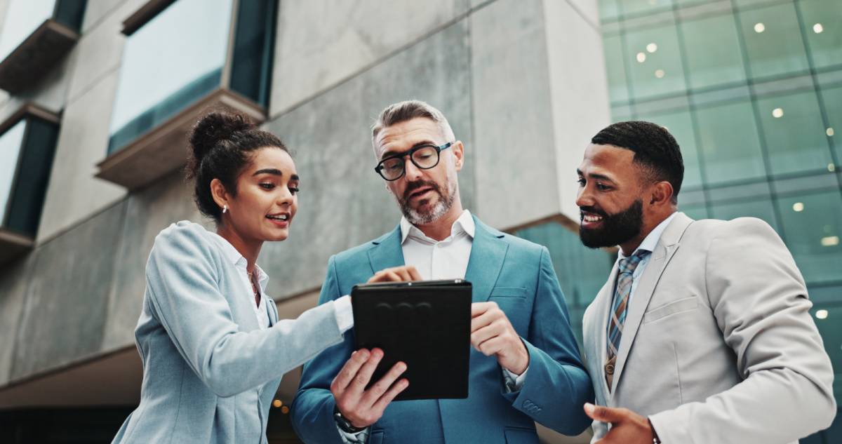 外でタブレットを見ながら話す男女