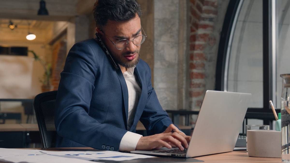 電話しながらタイピングしている男性