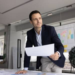  書類を片手に考える男性 