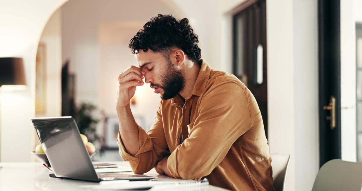 デスクで目頭を押さえる男性