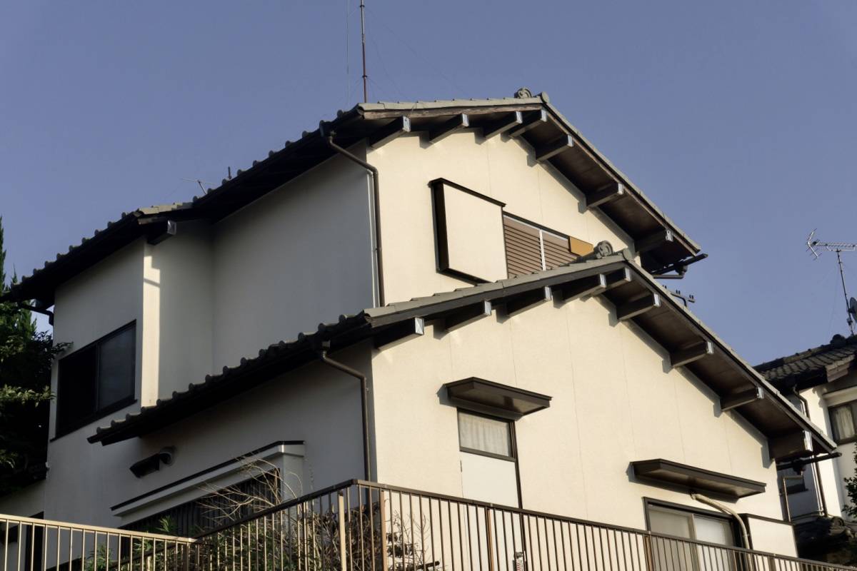 雨戸の閉まった2階建ての家