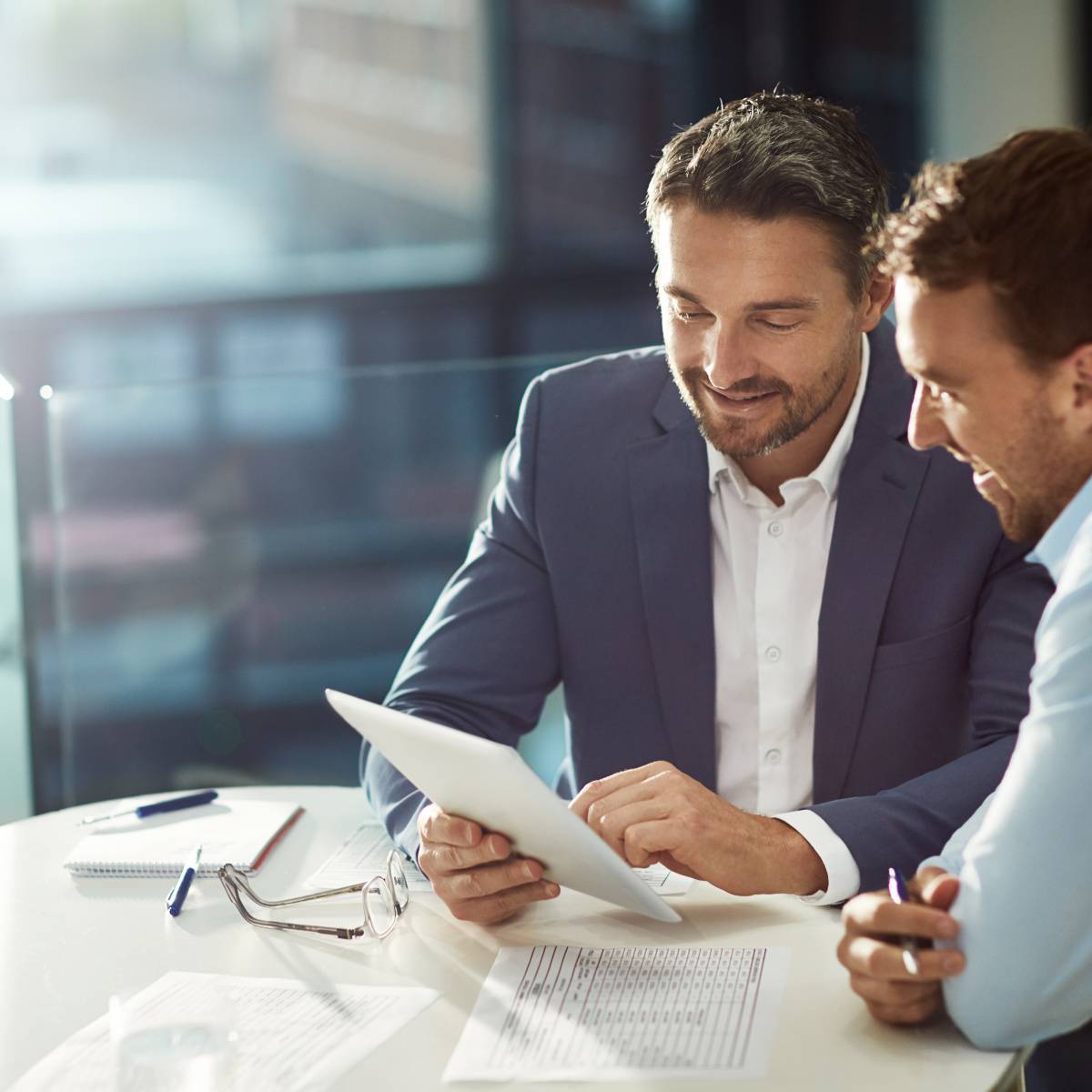 タブレットを見ながら話し合う2人の男性