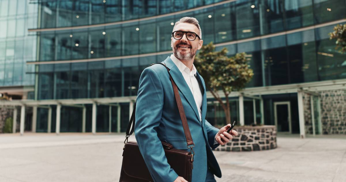 スマートフォンを片手に持ちながら歩く男性