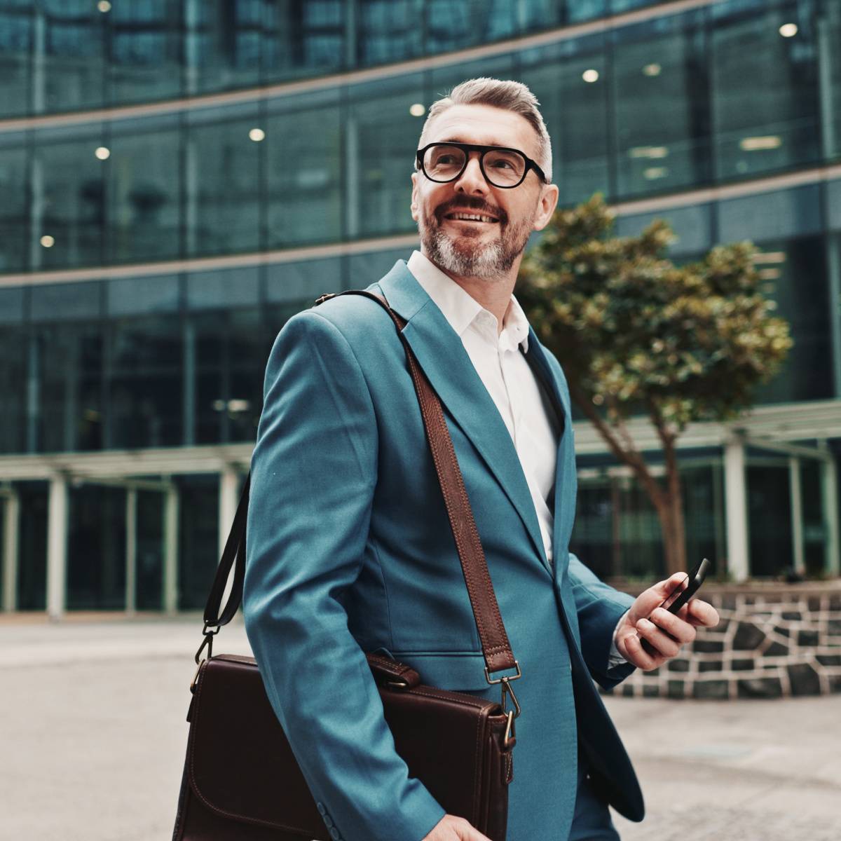 スマートフォンを片手に持ちながら歩く男性