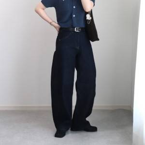  ブルーのカーディガンに黒パンツを合わせた女性 