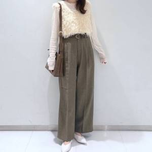  白トップスにブラウンのパンツを合わせた女性 