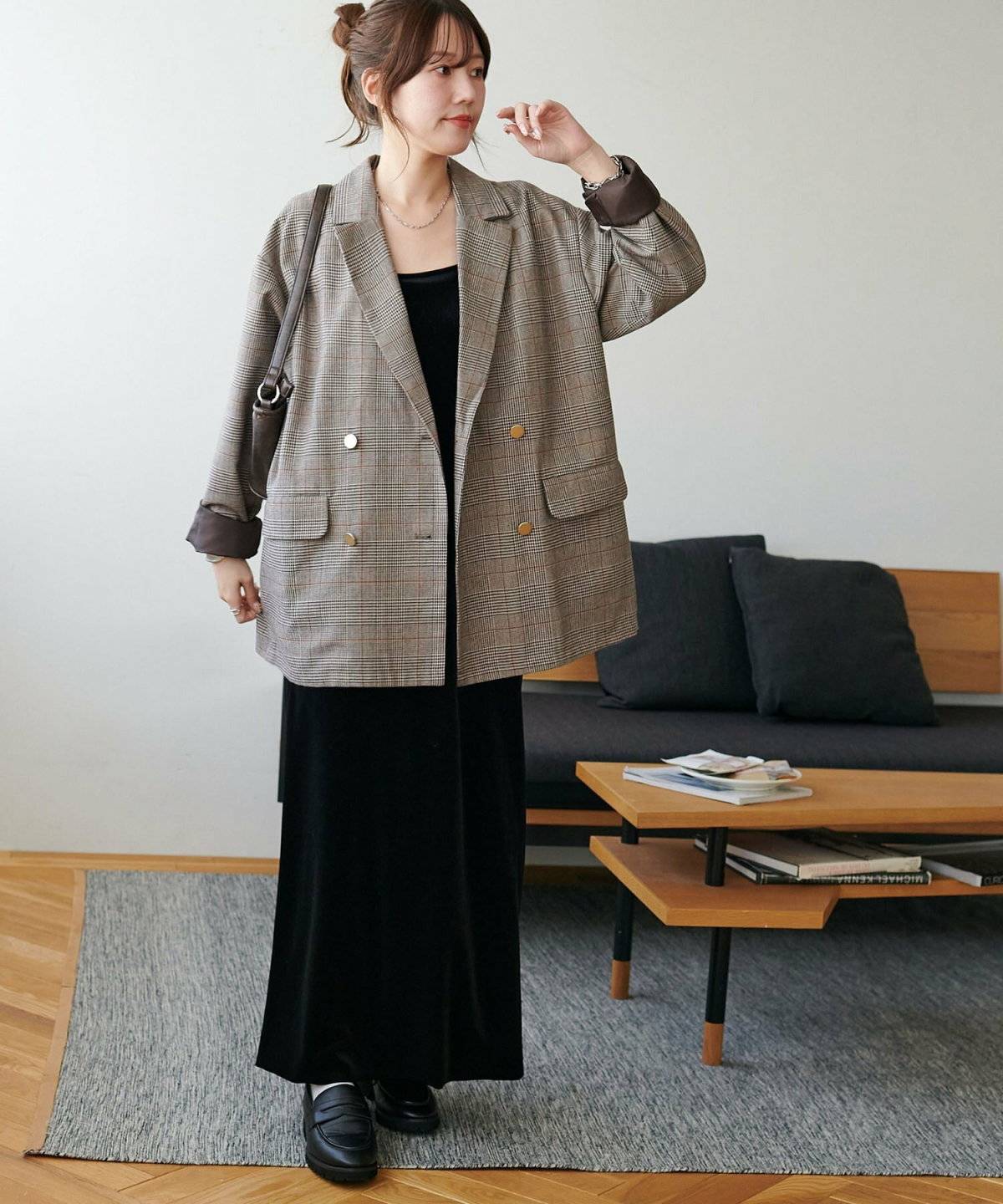 ブラックコーデにチェック柄ジャケットを羽織った女性