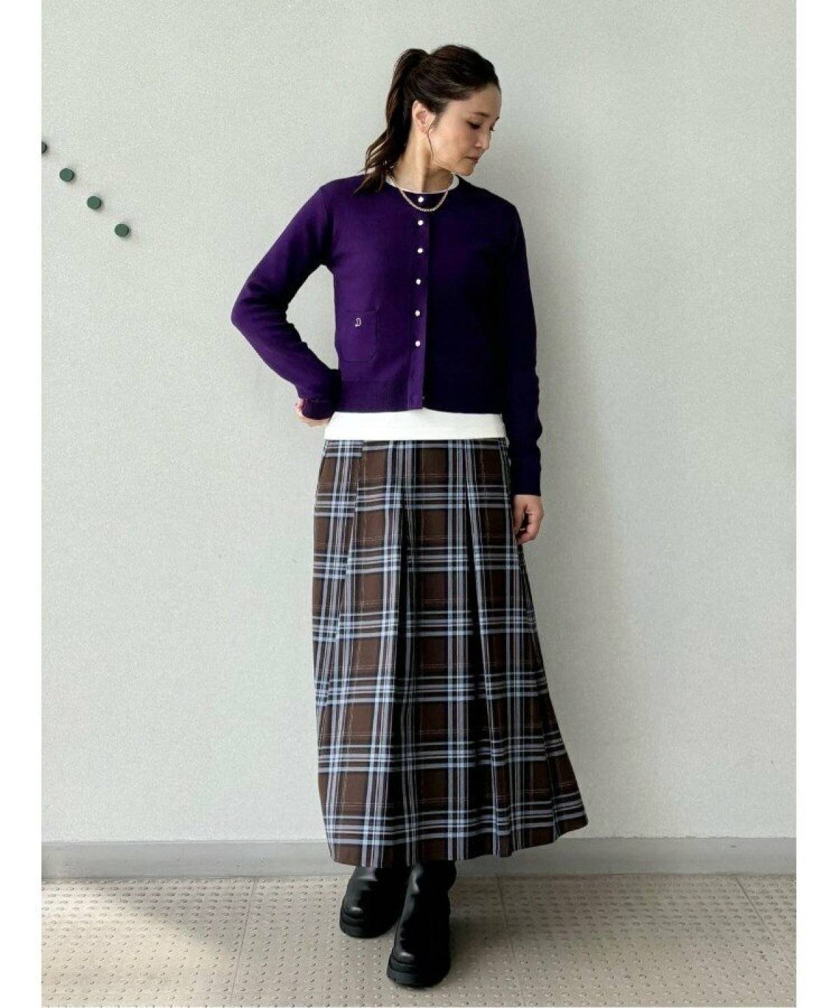 オレンジカーディガンにスカートを合わせた女性