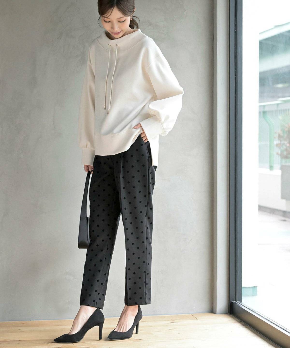 パーカーにドット柄パンツを合わせた女性