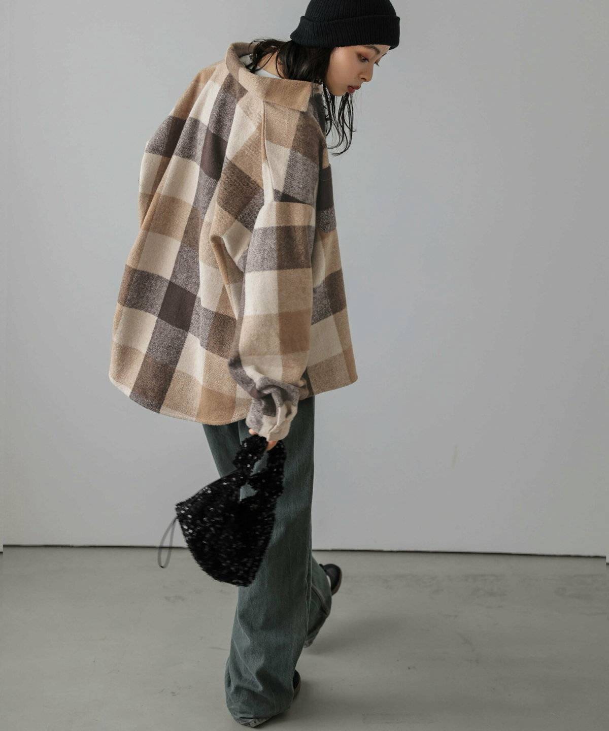 チェック柄のシャツにデニムを穿いた女性