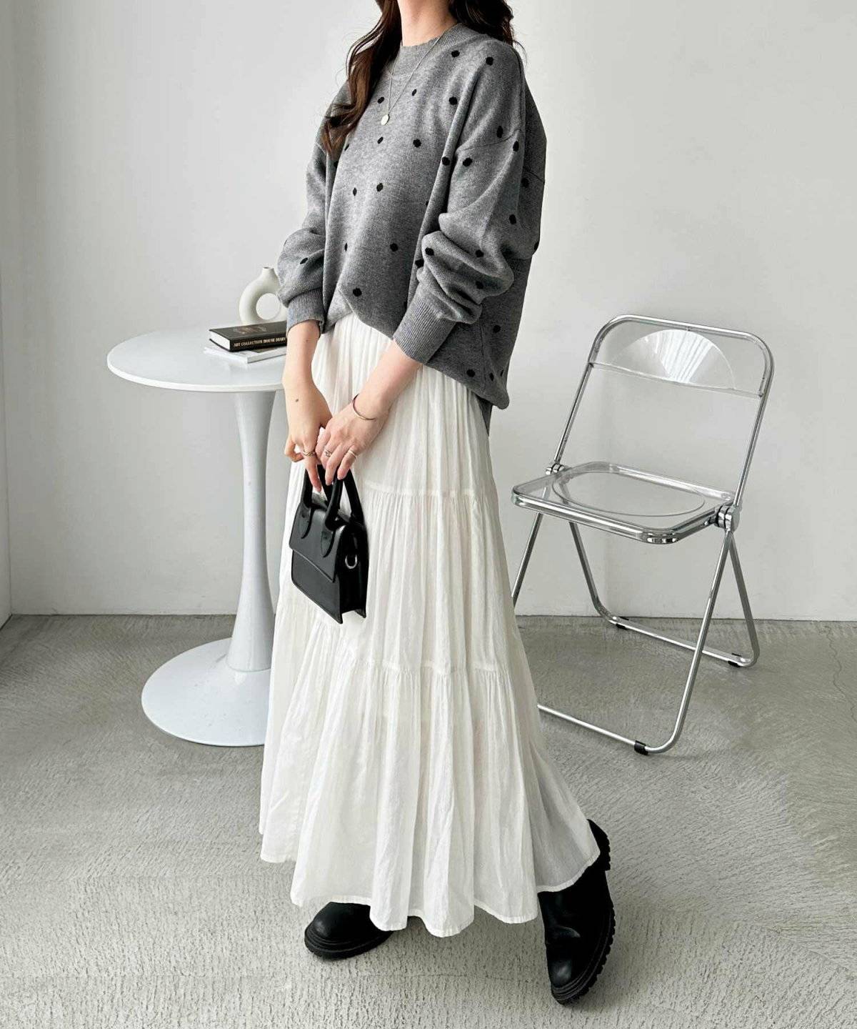 柄ニットに白スカートを合わせた女性
