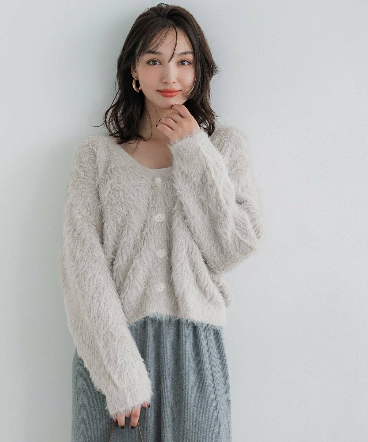 もこもこカーディガンにリブスカートを合わせた女性