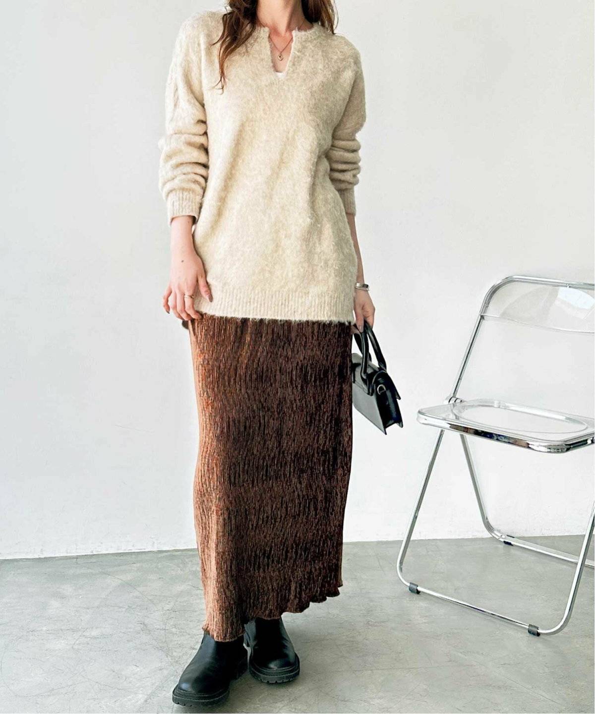 ベージュニットにブラウンのスカートを合わせた女性