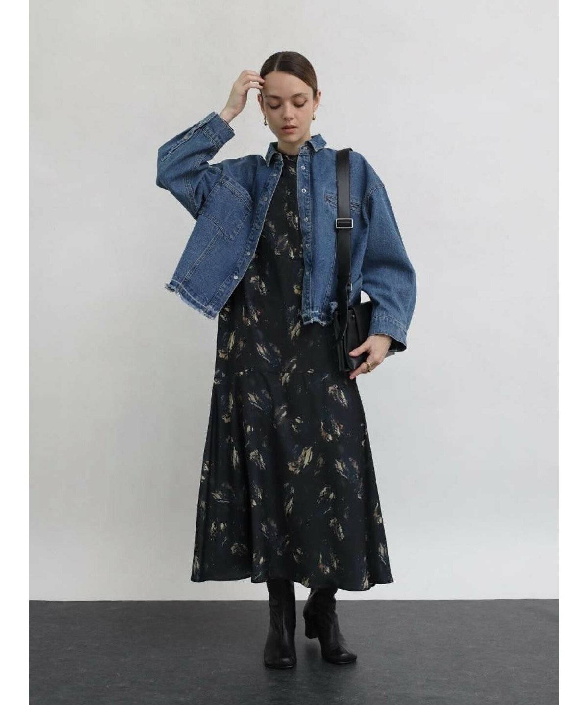 黒ワンピースにデニムジャケットを羽織った女性