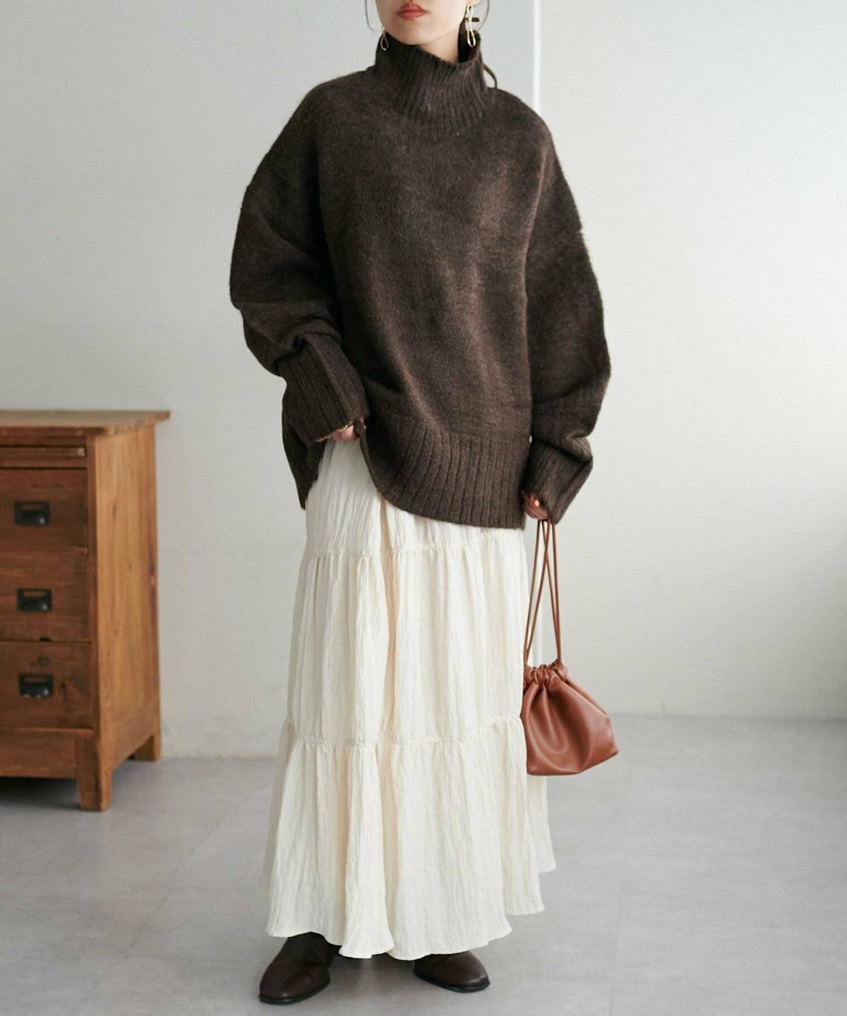 ニットに白スカートを合わせた女性