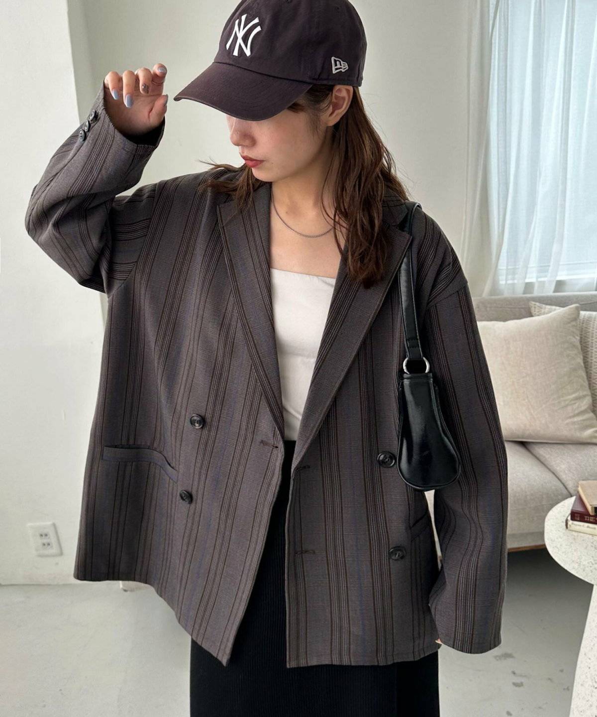 チェック柄ジャケットに黒スカートを合わせた女性