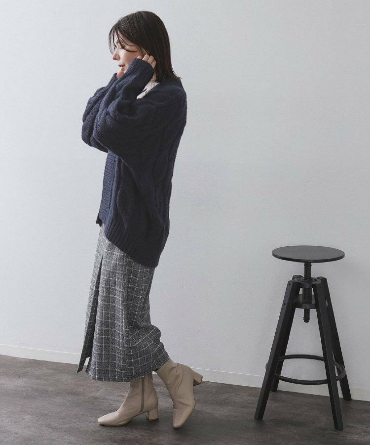 カーディガンにチェック柄スカートを合わせた女性