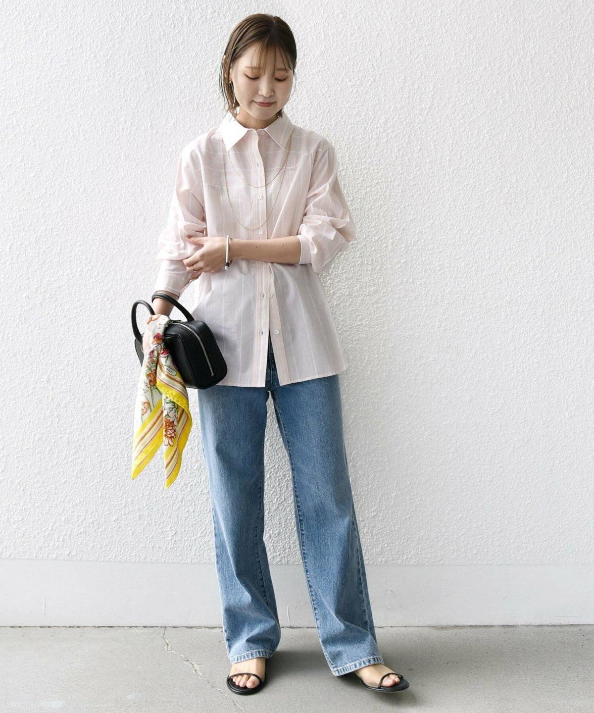 ピンクのシャツにデニムを合わせた女性