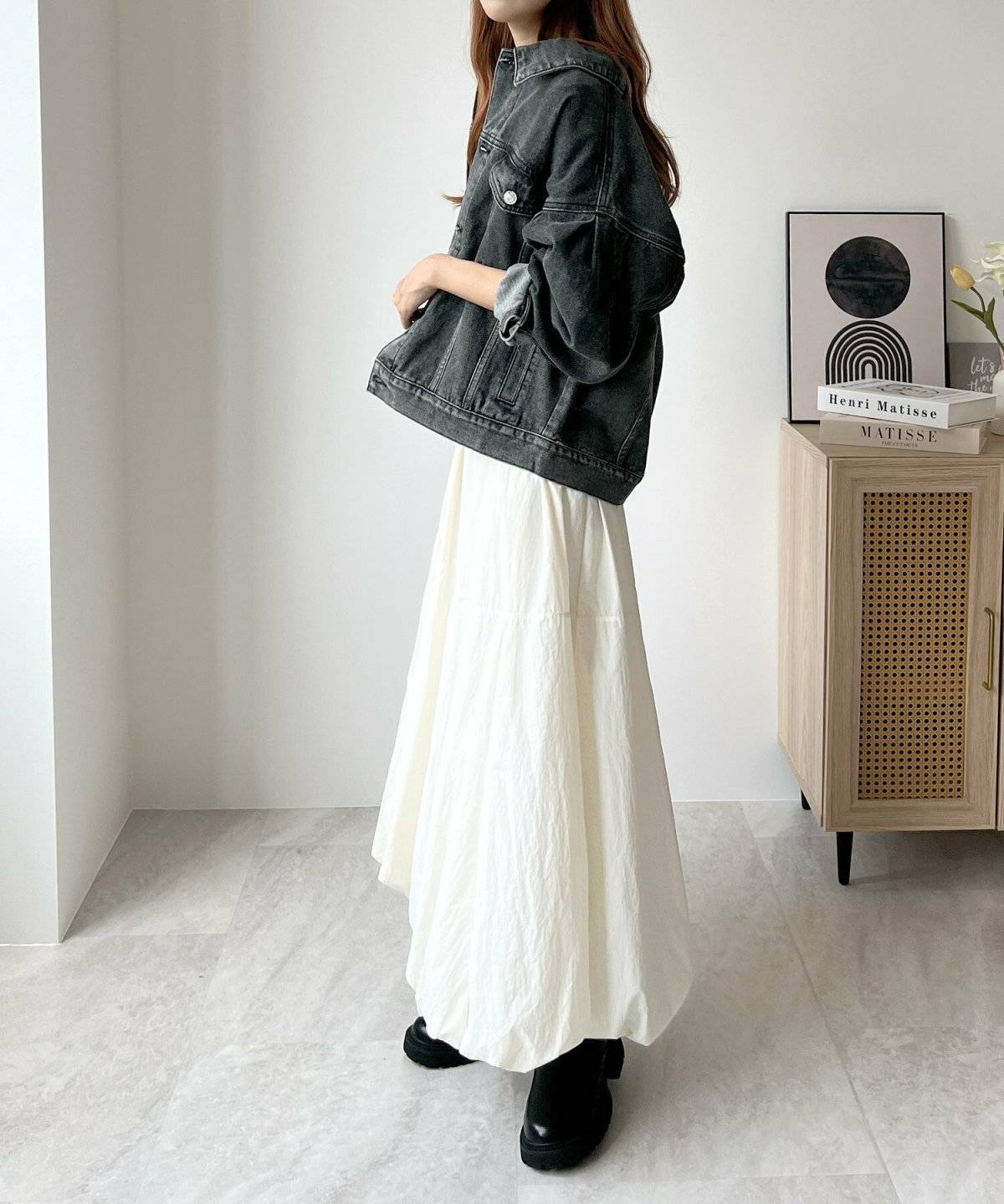白ロングスカートにデニムジャケットを羽織った女性