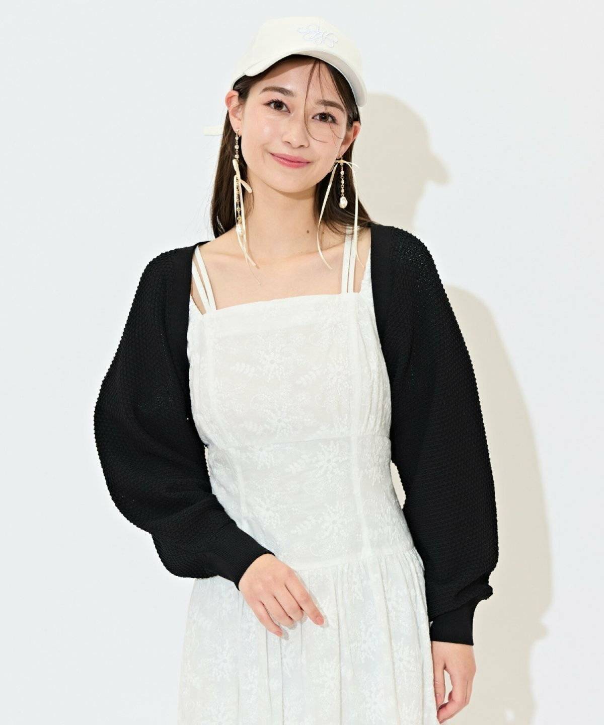 白ワンピースに黒ボレロを羽織った女性