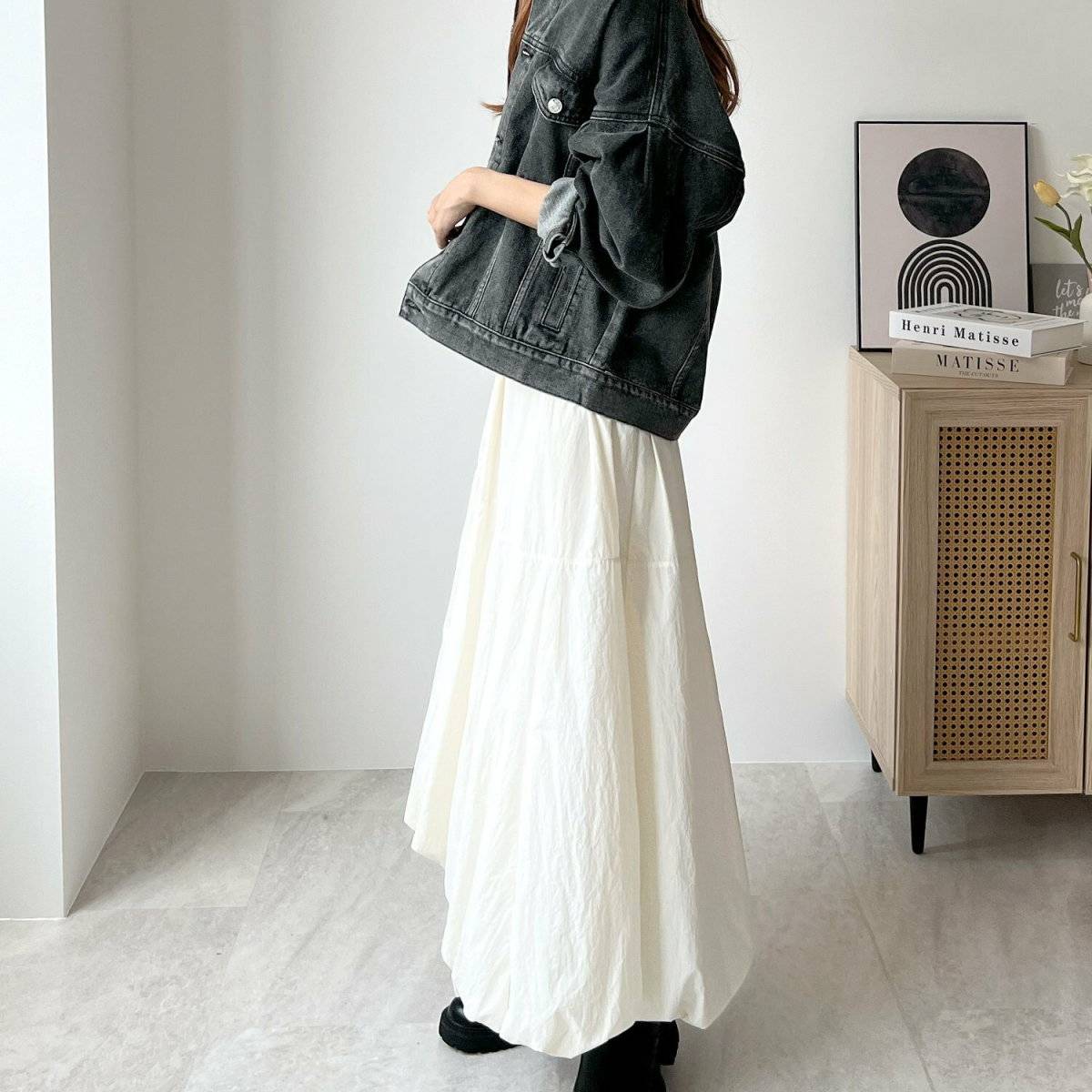 白ロングスカートにデニムジャケットを羽織った女性