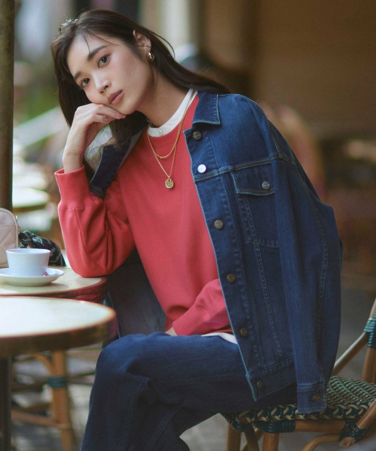 カラースウェットにデニムパンツを合わせた女性