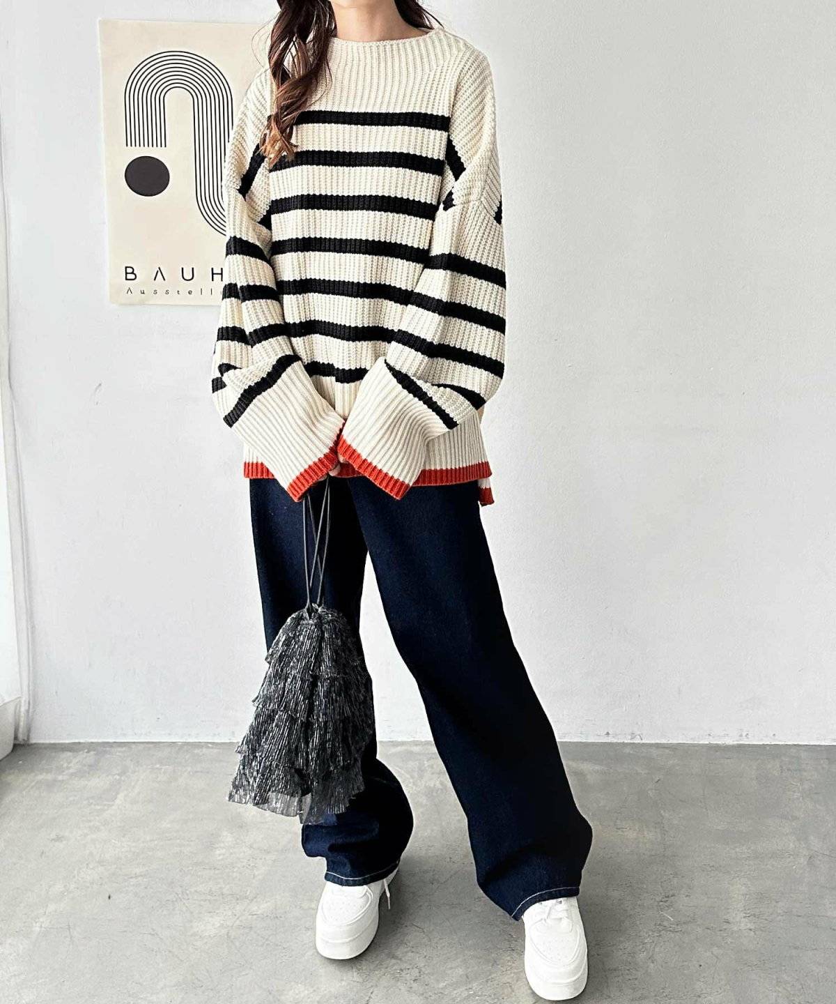 ボーダー柄ニットにパンツを合わせた女性